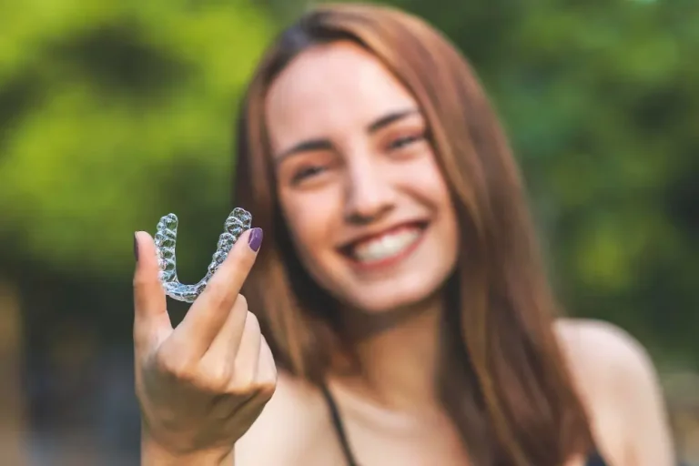 woman holding invisalign